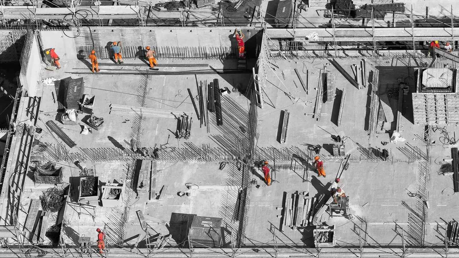 Aerial view of a multi-storey hospital construction site with workers on the slab