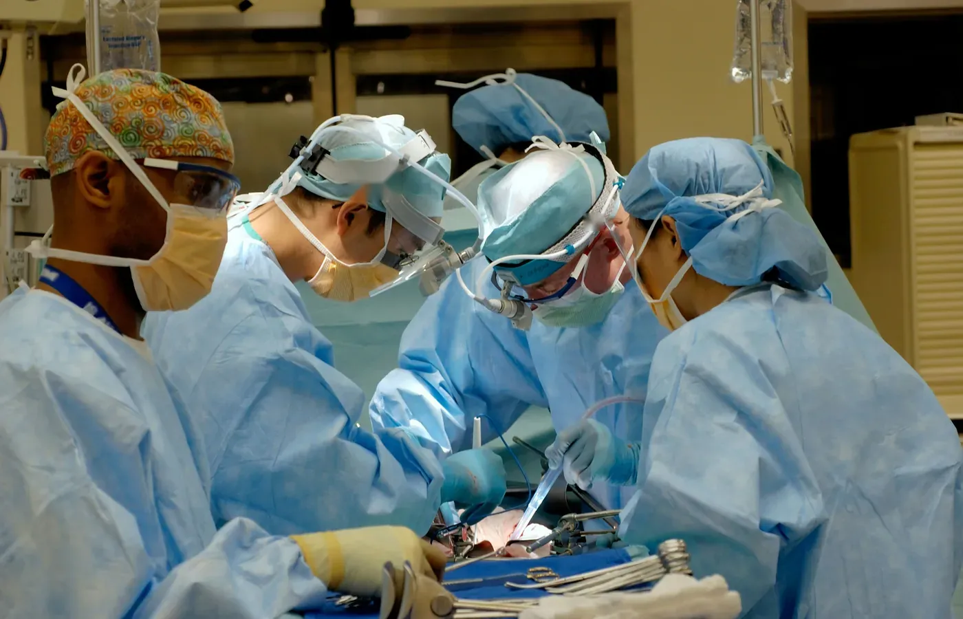 Surgical team at work in an operation theatre equipped with instrument trolleys